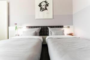 two beds sitting next to each other in a bedroom at elaya hotel wolfenbuettel, Trademark Collection by Wyndham in Wolfenbüttel