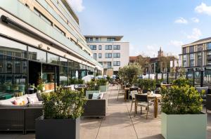 a patio with tables and chairs on a building at elaya hotel kleve, Trademark Collection by Wyndham in Kleve