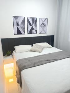 a bedroom with two beds with white sheets at Apartamento 2QTS aconchegante in Vila Velha
