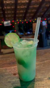a drink with a lime slice in a cup on a table at Hostel Pantera do Rosa in Praia do Rosa