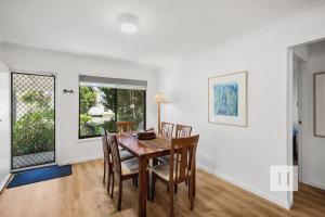 a dining room with a table and chairs at Garden Cottage Noraville in Toukley