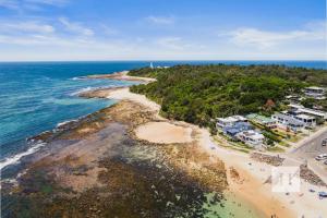 an aerial view of a beach with houses and the ocean at Garden Cottage Noraville in Toukley