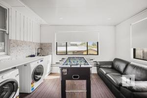 a living room with a couch and a foosball table at Sunset Shore Retreat in Summerland Point
