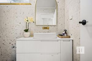 a bathroom with a white sink and a mirror at Sunset Shore Retreat in Summerland Point +21 photos