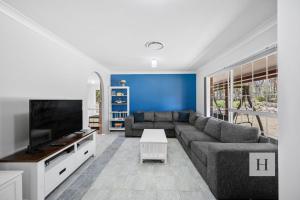 a living room with a couch and a flat screen tv at Jilliby Honey Farm in Jilliby