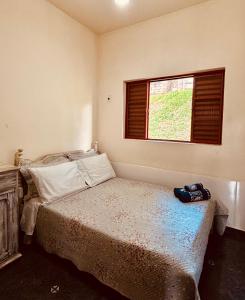 a bedroom with a bed and a window at Pousada Flat Royal - Flat 03 in Itapecerica