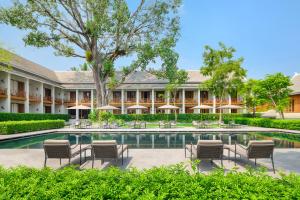 an exterior view of the resort with chairs and a swimming pool at Avani+ Luang Prabang Hotel in Luang Prabang