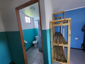 a bathroom with a toilet and a wooden ladder at Cabañas Kai Rau Tu in Hanga Roa +35 photos