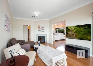 a living room with a couch and a table at Tide view in Toukley