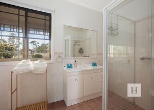 a white bathroom with a shower and a sink at Tide view in Toukley +20 photos