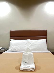 a white hat sitting on top of a bed at Olive Suites in Cagayan de Oro