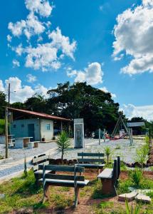 a group of benches in front of a playground at Pousada Flat Royal - Flat 03 in Itapecerica +14 photos