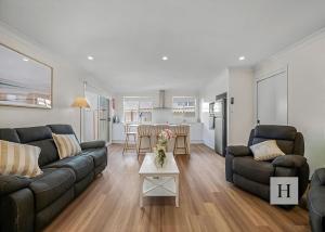 a living room with a couch and a table at Pete's Retreat -500m from the beach in Norah