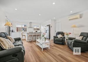 a living room with two couches and a kitchen at Pete's Retreat -500m from the beach in Norah +8 photos
