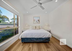 a bedroom with a bed and a large window at Pete's Retreat -500m from the beach in Norah