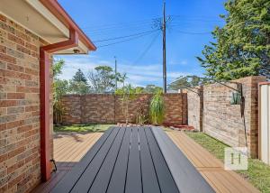 a wooden deck in front of a brick wall at Pete's Retreat -500m from the beach in Norah