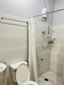 a bathroom with a toilet and a shower at Olive Suites in Cagayan de Oro +4 photos