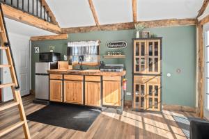 a kitchen with green walls and wooden cabinets at Valley View Hideaway Cabin with Mountain Views in Miramonte