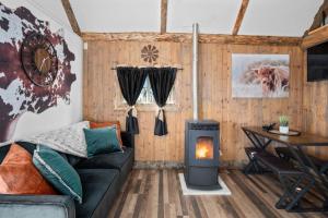 a living room with a couch and a wood stove at Valley View Hideaway Cabin with Mountain Views in Miramonte
