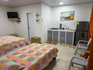 a room with two beds and a kitchen with a sink at Posada Three Cay Suites in Providencia +153 photos