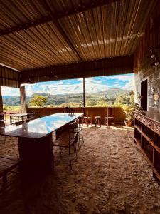 a large room with a table and chairs and a large window at Pousada Flat Royal - Flat 03 in Itapecerica