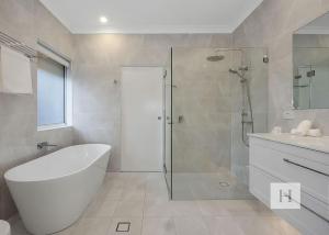 a white bathroom with a tub and a shower at Angels Little Haven in Cams Wharf +25 photos