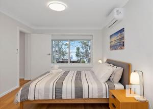 a bedroom with a large bed with a window at Angels Little Haven in Cams Wharf