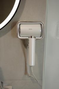 a soap dispenser in a bathroom with a pipe at Una Hotel in Mantaak