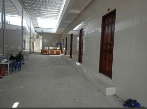 an empty hallway of a building with a person sitting on a chair at Nhà Nghỉ La Gi in Lagi