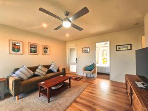 a living room with a couch and a ceiling fan at Summer Villa in Kiama +10 photos