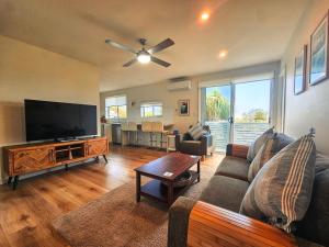 a living room with a couch and a flat screen tv at Summer Villa in Kiama