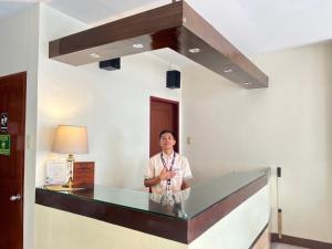 a man standing at a desk in a room at Olive Suites in Cagayan de Oro