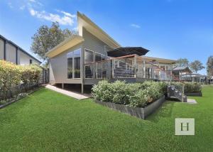 a house with a lawn in front of it at Karinyah in Summerland Point