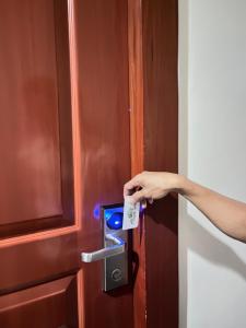 a person opening a door with a key in it at Olive Suites in Cagayan de Oro