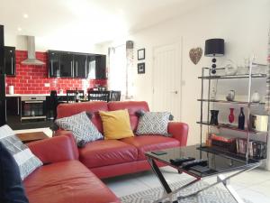 a living room with a red couch and a table at Railway Cuttings in Falstone