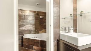 a bathroom with a sink and a bath tub at New York Style Apartment in Bendigo