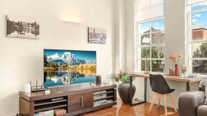 a living room with a tv on a wall at New York Style Apartment in Bendigo