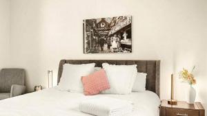 a bedroom with a white bed with a pink pillow at New York Style Apartment in Bendigo