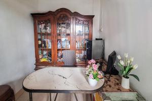 a room with a table and a wooden china cabinet at Villa Citra Syariah RedPartner in Kalibata 1 +17 photos
