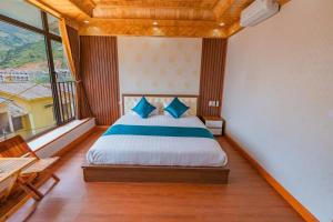 a bedroom with a bed and a large window at Bong's House Sapa in Sapa
