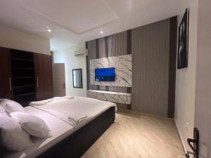 a bedroom with a bed and a tv on a wall at Lekki Waterfront Terrace shortlet with Oceanview, Attendants and private Jetty in Lagos +103 photos