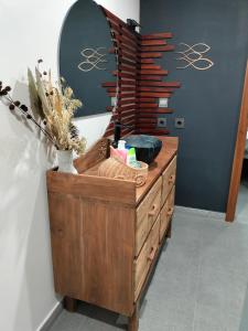 a bathroom with a wooden dresser and a mirror at Villa Claudine in Ambengan