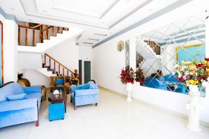 a living room with blue chairs and a staircase at Hotel Trâm Anh 1 in Nhơn Trạch +2 photos