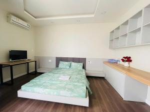 a small room with a bed and a desk at Hotel Trâm Anh 1 in Nhơn Trạch
