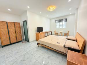 a bedroom with a bed and a table and a television at Hotel Trâm Anh 1 in Nhơn Trạch