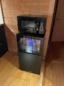 a microwave oven sitting on top of a refrigerator at A Sleeping Forest in Ito +53 photos