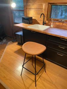 a kitchen with a sink and a stool next to a counter at A Sleeping Forest in Ito