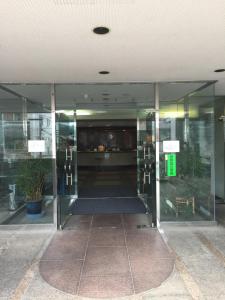 uma entrada para um edifício de escritórios com portas giratórias em HOTEL CROWN HILLS FUJINOMIYA em Fujinomiya