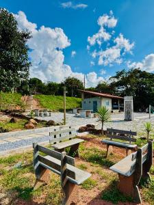 a group of benches sitting in a park at Pousada Flat Royal - Flat 03 in Itapecerica