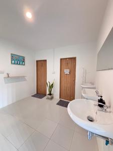 a white bathroom with a sink and a mirror at Bingo Hostel Khao Sok in Khao Sok National Park +82 photos